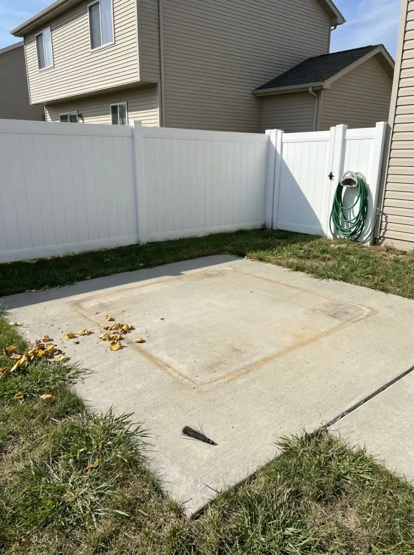 Same backyard with hot tub removed and concrete pad swept clean